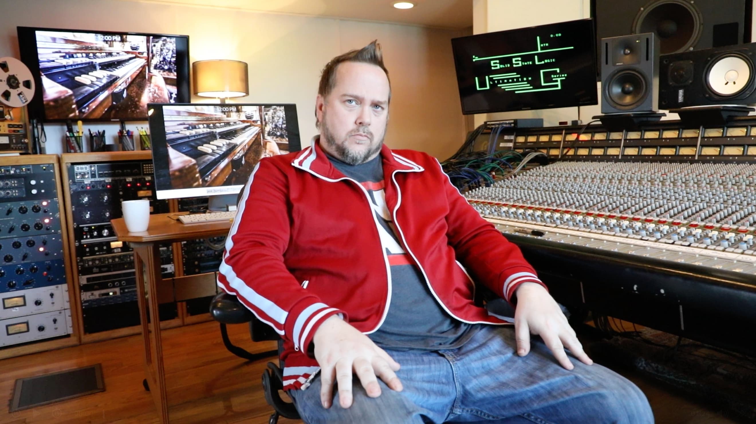 Kene Bell seated at a large-format studio mixing console