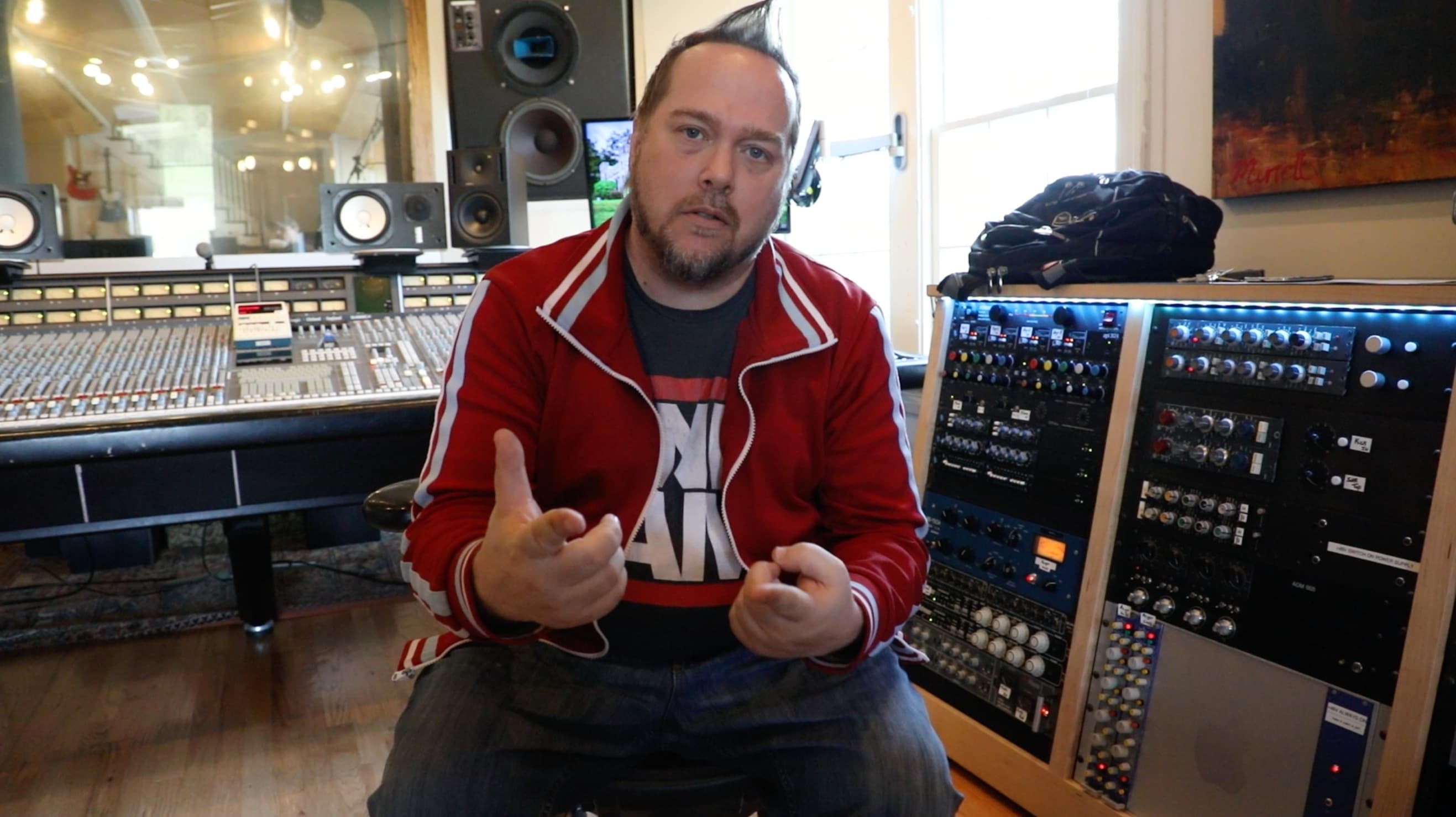 Kene Bell in conversation beside a studio mixing console
