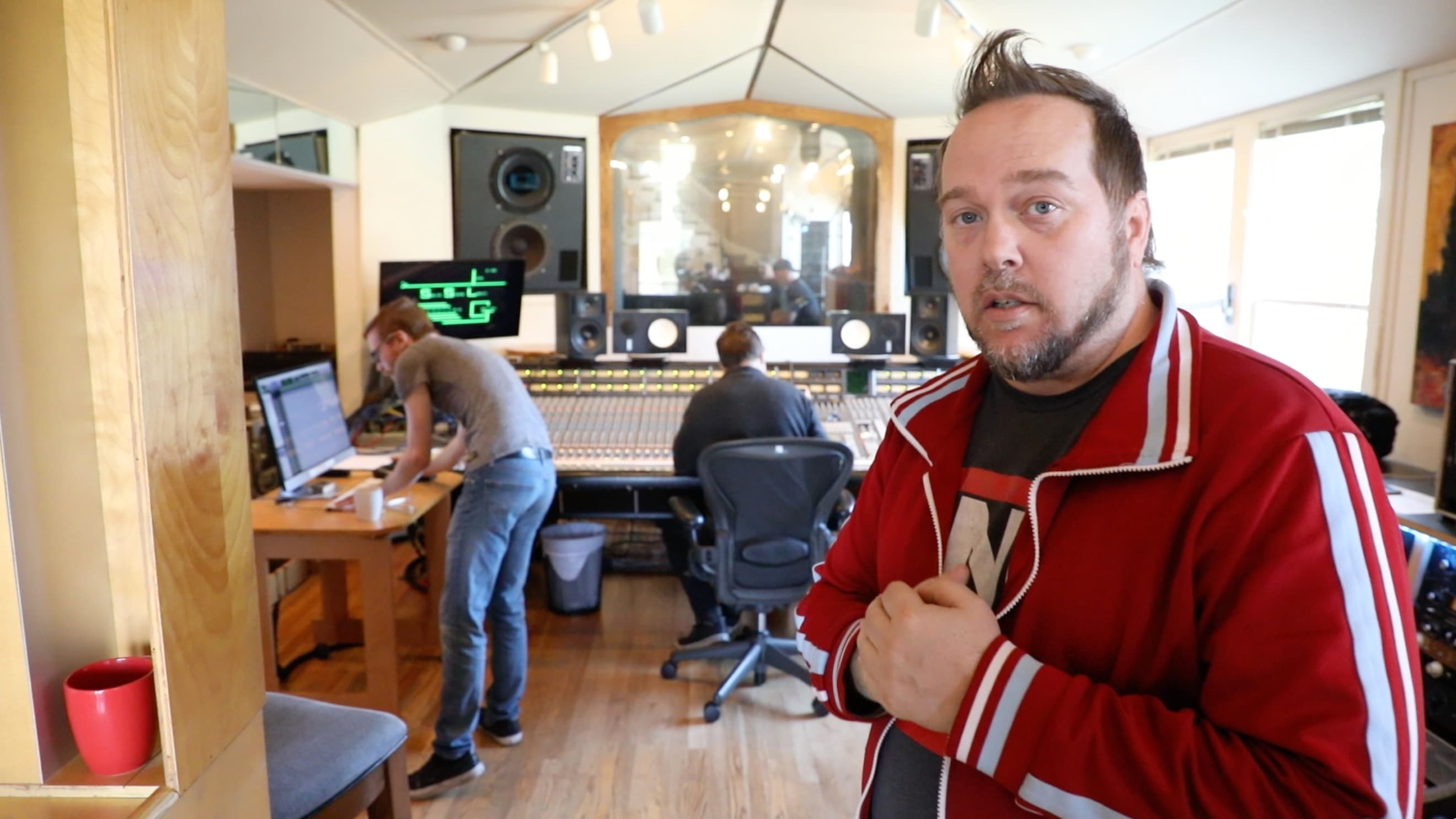 Kene Bell standing in an active recording studio with collaborators